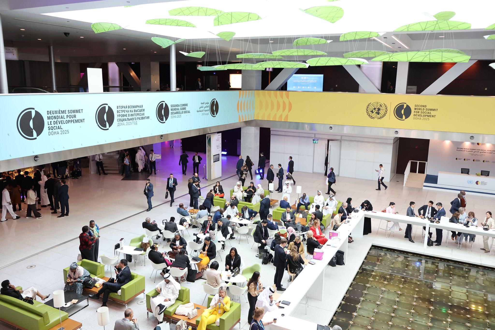 Les participants échangent dans un vaste hall événementiel lors du deuxième Sommet mondial pour le développement social (WSSD2) à Doha, en 2025.