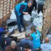 Сотрудники УВКБ UNHCR раздают гуманитарную помощь, включая матрасы и одеяла, группе людей из грузовика в Ливане.