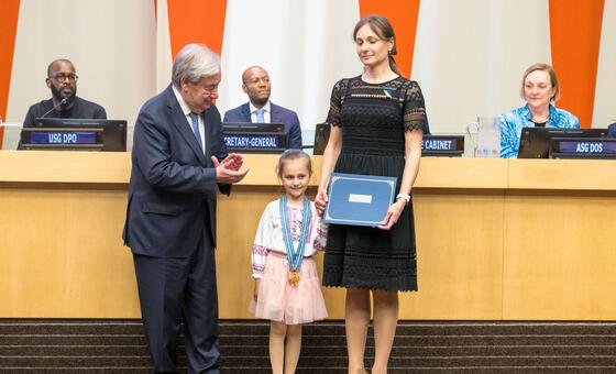 UN Secretary-General António Guterres presents an award to the family of Ukrainian peacekeeper Sergei Prykhodko at a formal ceremony.
