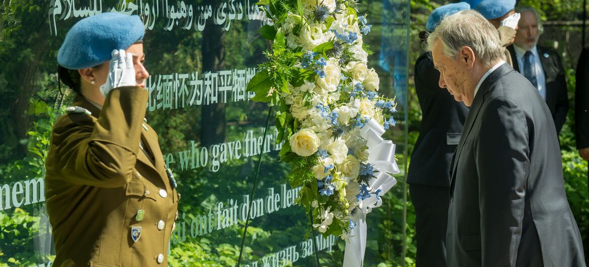 UN Secretary-General António Guterres and a female peacekeeper in uniform at a wreath laying ceremony for fallen peacekeepers at the UN Headquarters.