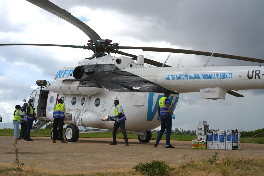Wafanyakazi wa uokoaji wakipakia vifaa kwenye helikopta ya Huduma ya Anga UMOJA WA MATAIFA katika eneo la uwanjani katika Jamhuri ya Kidemokrasia ya Kongo.