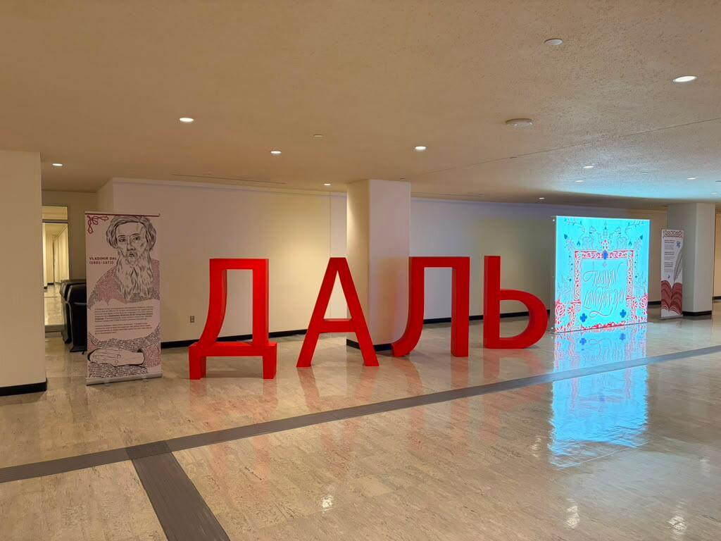 Большое крытое выставочное пространство, где крупными красными объемными буквами написано кириллическое слово «ДАЛЬ» (DAL).