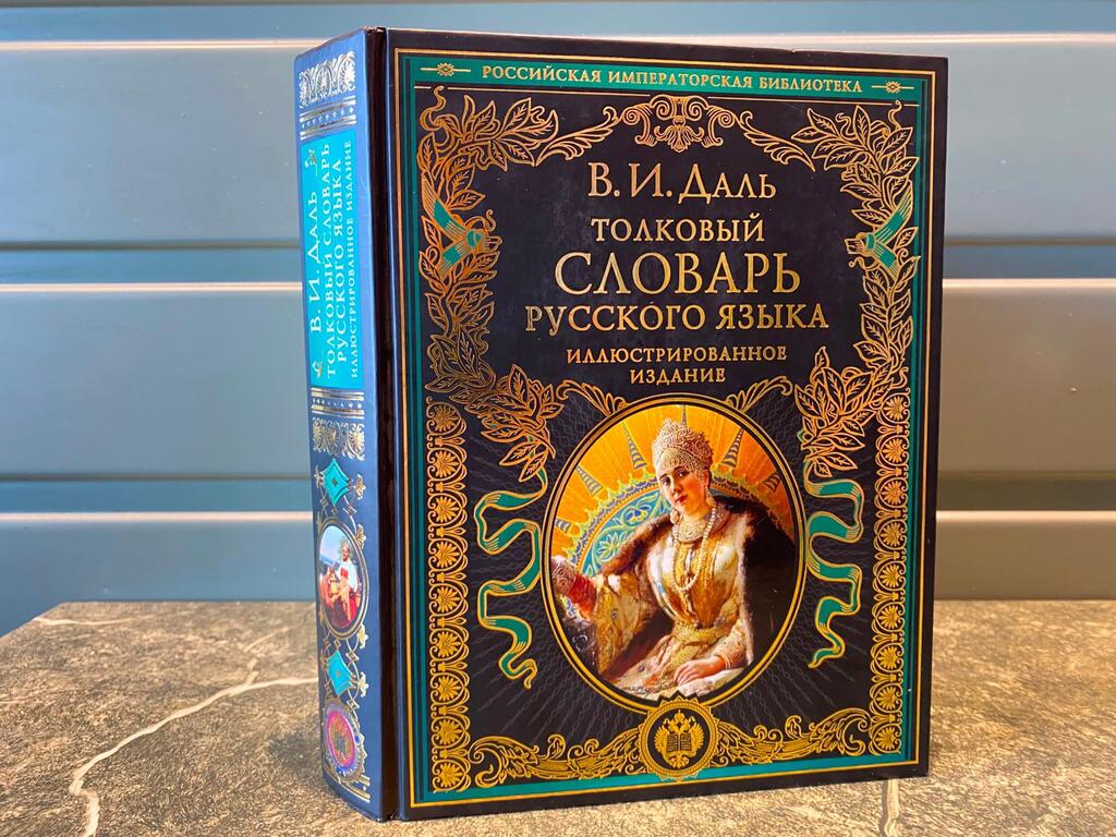 Книга в твердом переплете под названием «Русский словарь русского языка» В.И. Даля, с богато украшенной обложкой, на которой изображен портрет женщины в историческом костюме.