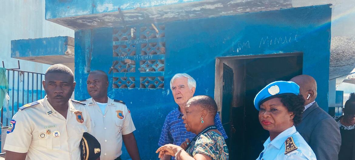 An OHCHR official visits a community in Haiti, accompanied by local police officers, at a site for the UNMINHAT mission.