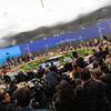 Делегаты присутствуют на тематической сессии саммита РКИК ООН по вопросам перехода к энергетике, на фоне большого конференционного стола и изображений ветряных турбин.