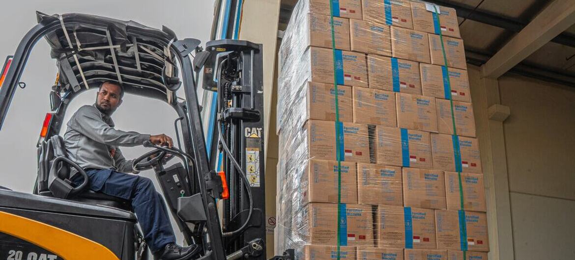 Марва Авад, сотрудник Всемирной продовольственной WFP) по связям с общественностью в странах Персидского залива, сидит за погрузчиком CAT, управляя им на складе Управления ООН по развитию человеческих ресурсов в Дубае. Она находится рядом с большим поддоном высококалорийного печенья, входящего в состав 400-тонной партии пищевой помощи от Всемирной продовольственной программы, предназначенной для Афганистана.