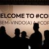 Siluetas de personas se encuentran frente a un gran letrero que dice 'BIENVENIDOS A #COP30' y 'BEM-VINDO(A) A #COP30' en el evento de la CMNUCC en Belém.