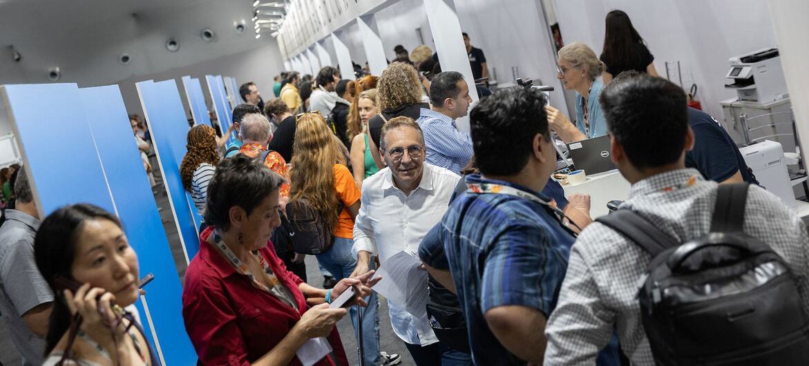 A crowded indoor venue at the UNFCCC COP29 conference in Belém, Brazil, with attendees at a registration desk.