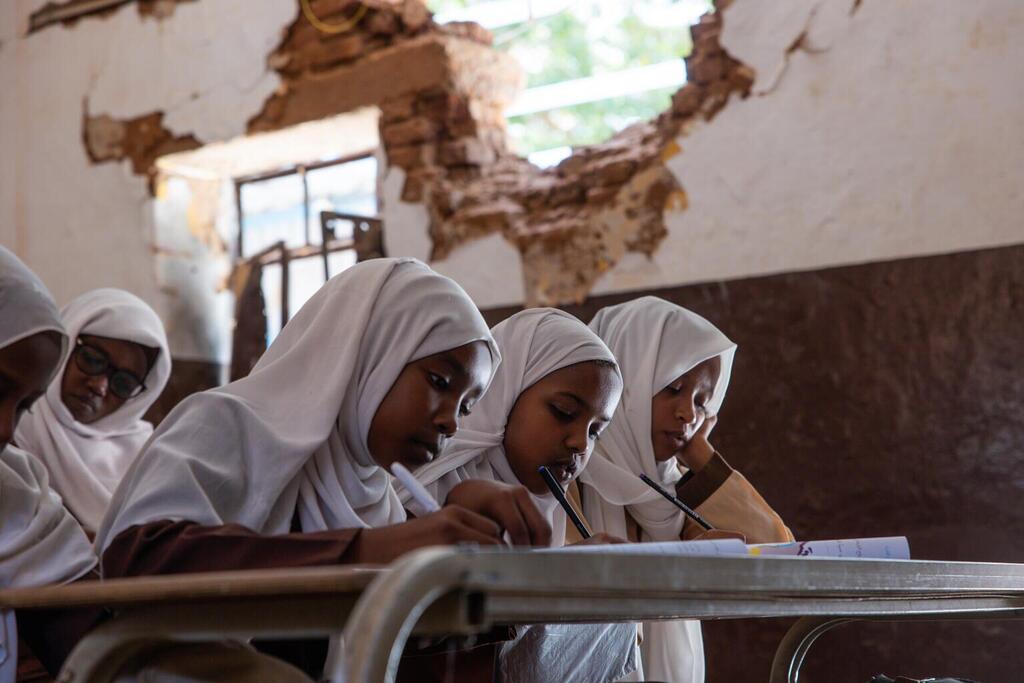 Des élèves assistent à un cours dans une salle de classe partiellement détruite de l'école primaire pour filles Amina Bint Wahb, dans l'État de Khartoum, au Soudan.