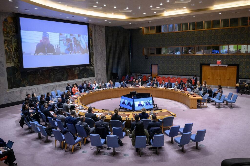 A wide view of the United Nations Security Council chamber in New York, with delegates seated around a large circular table during a meeting.