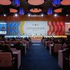 A large conference hall during the Second World Summit for Social Development, with a speaker at a podium and a large screen displaying the event title and a presentation.