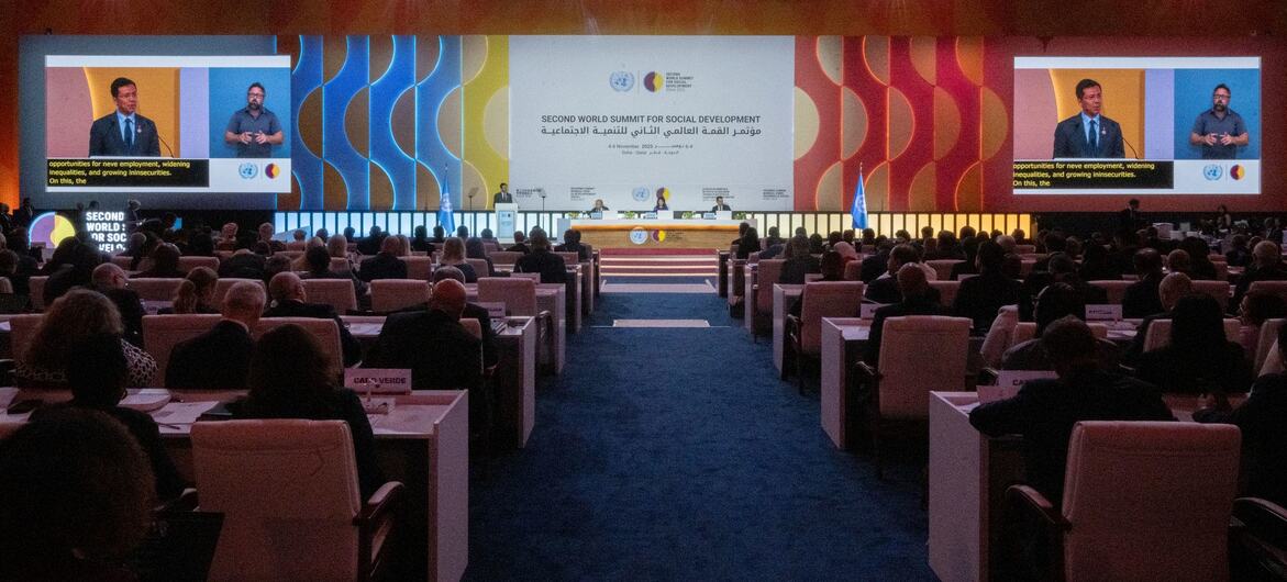 A large conference hall during the Second World Summit for Social Development, with a speaker at a podium and a large screen displaying the event title and a presentation.