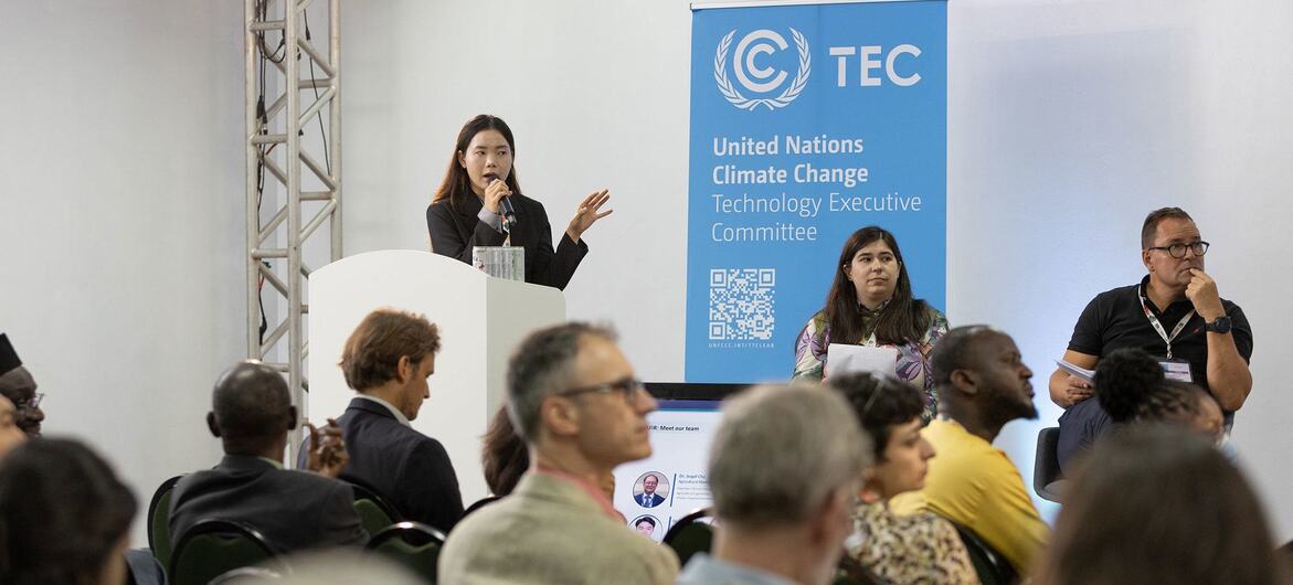 Uma mulher discursa em um pódio durante uma reunião do Comitê Executivo de Tecnologia para Mudanças Climáticas das Nações Unidas .