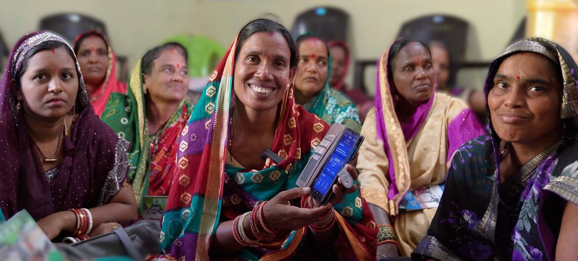 ग्रामीण ओडिशा में अनिश्चित जलवायु से निपटने के लिए एक सरल ऐप का इस्तेमाल करती महिला किसान.