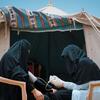 Медицинский работник UNFPA) в Йемене измеряет артериальное давление пациентки во временной палатке.