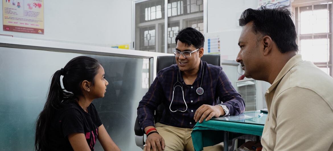 A doctor consults with a young girl and her father in a clinic in India, as part of a UNICEF diabetes treatment program.