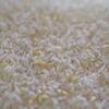 Primer plano de un montón de granos de arroz blanco fortificado con enriquecimientos nutricionales amarillos visibles.