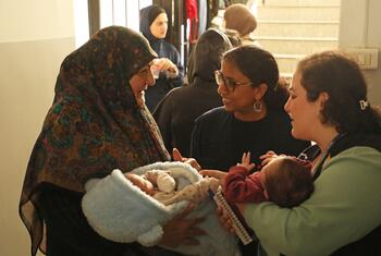أنانديتا فيليبوز، ممثلة UNFPA في لبنان، تتحدث مع النساء والأمهات اللواتي يحملن أطفالهن حديثي الولادة في أحد الملاجئ.