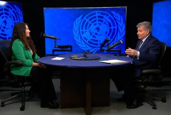 Guy Ryder, Under Secretary-General for Policy, is interviewed by a female journalist at a round table in a UN News studio.