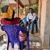 L’anthropologue de l’OMS Julienne Anoko est assise sur une véranda à Bunia, en RDC, et discute avec une femme qui a perdu des membres de sa famille à cause d’Ebola.