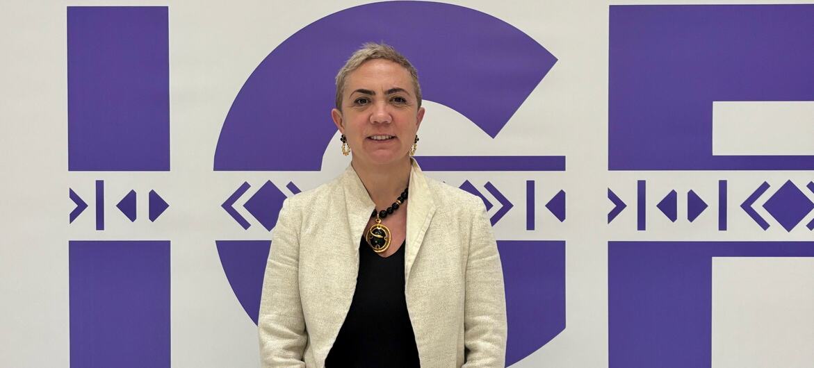 Portrait of Ivana Bartoletti standing in front of a white wall with a purple IGF logo.