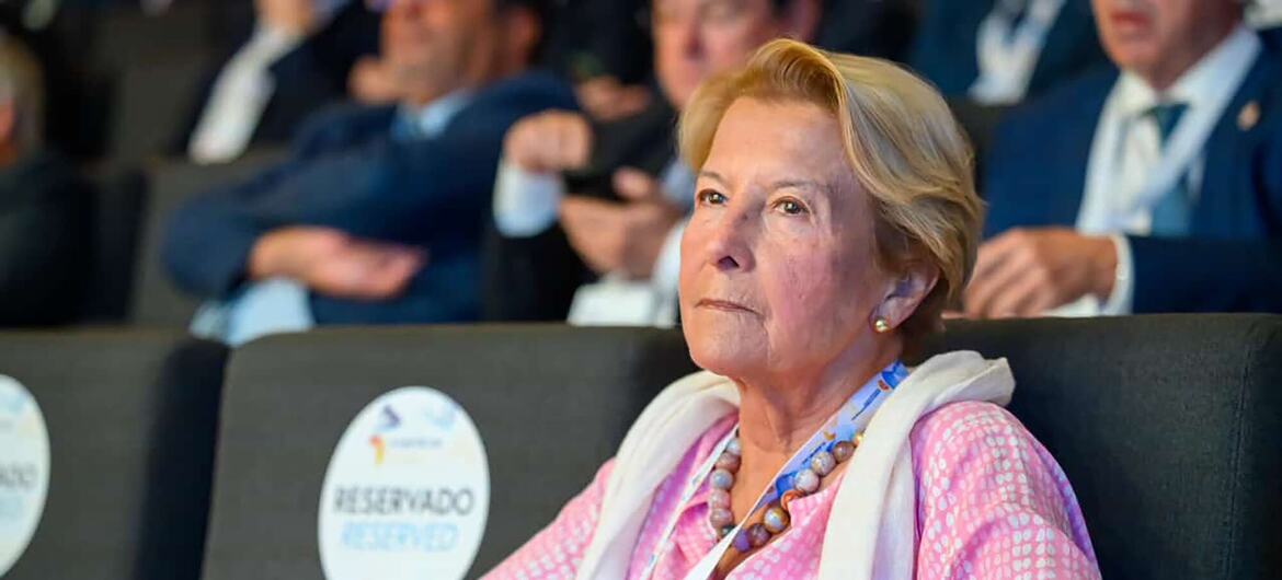 A diplomata portuguesa idosa Ana Martinho assiste a um evento formal sentada na plateia.