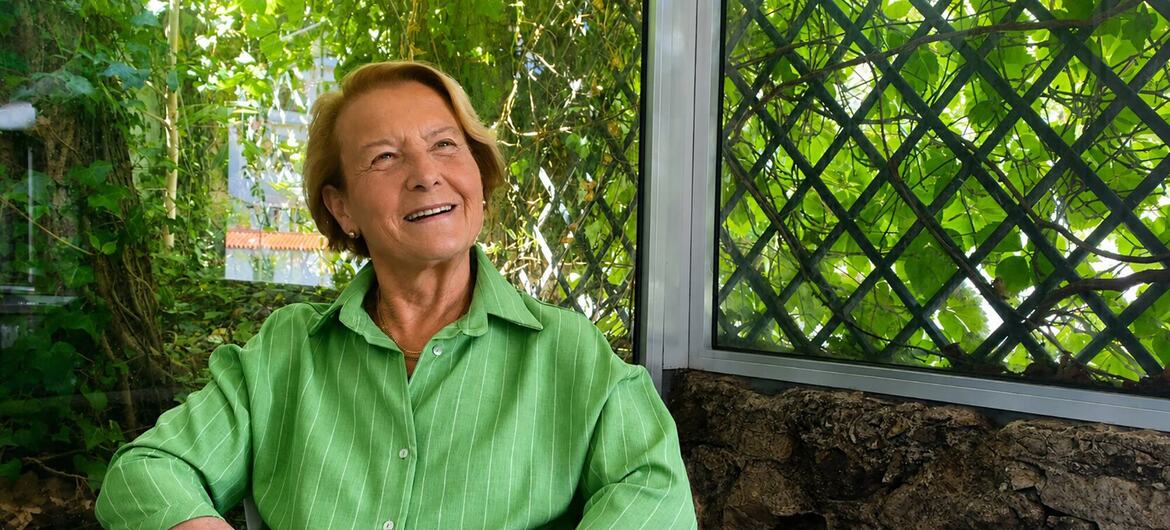 A diplomata portuguesa Ana Martinho sorri enquanto está sentada em um jardim.