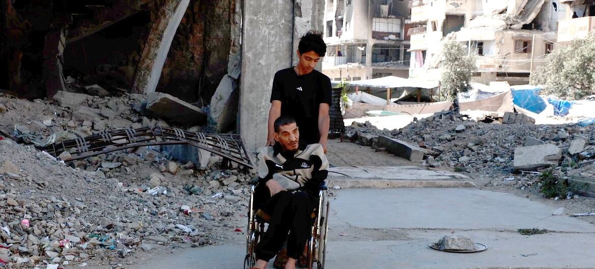 Mwanamume anayeitwa Moayad anamsukuma baba yake, Saeed Bakroun, kwenye kiti cha magurudumu kupitia kifusi huko Gaza.