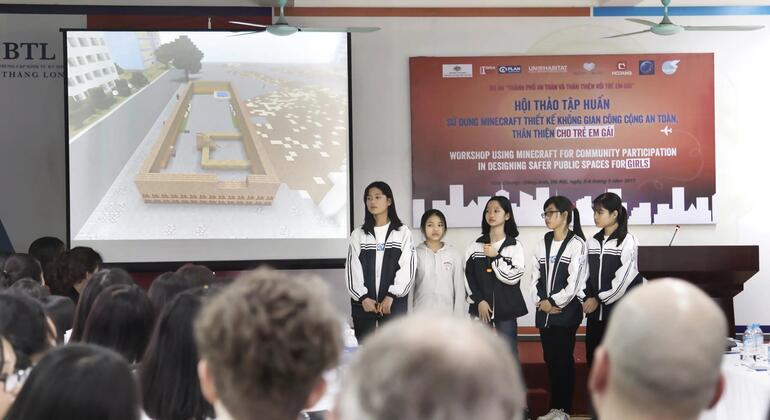 Cinq jeunes femmes en uniforme scolaire se tiennent sur scène devant un public, animant un atelier sur l'utilisation de Minecraft pour concevoir des espaces publics plus sûrs pour les filles.