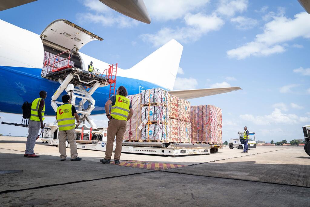 Des employés du PAM déchargent des fournitures de secours d'urgence d'un avion C-130 à l'aéroport international d'Entebbe en Ouganda, dans le cadre de la riposte à l'épidémie d'Ebola en RDC.