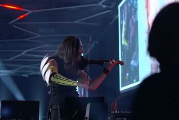 Un violinista con inteligencia artificial y brazo robótico actúa en el escenario del encuentro mundial sobre gobernanza de la IA en Ginebra.