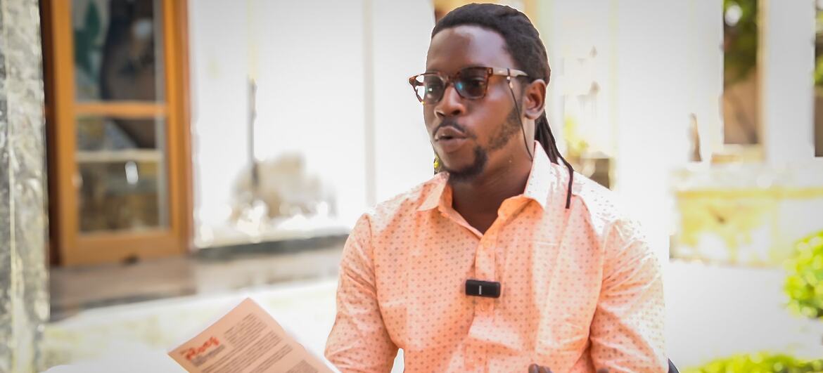Clark Liodess Kaya, écrivaine et influenceuse, prend la parole en tenant un livre lors d'un événement à Dakar.