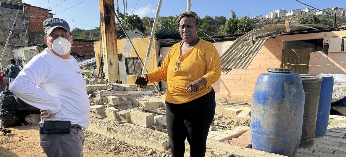 Un hombre y una mujer permanecen de pie entre los escombros de una zona residencial en Venezuela tras un terremoto.
