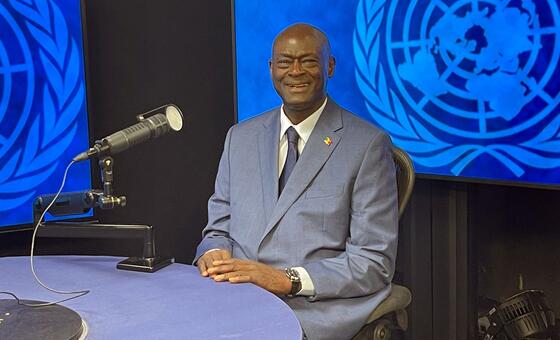 Professor Serigne Gueye, a Senegalese urologist, sits at a table with a microphone in front of him during an interview with the UN.