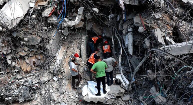 فريق من الدفاع المدني الفلسطيني يبحث عن رفات الضحايا تحت الأنقاض.