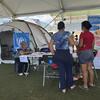 Un miembro del personal del ACNUR ayuda a los refugiados en un mostrador de registro bajo una carpa en un campamento de refugiados en Venezuela.