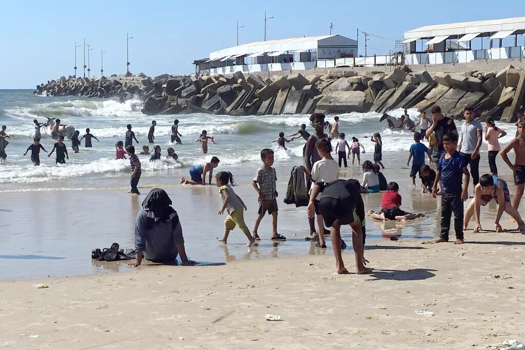 Sur la plage de Gaza, des enfants jouent et nagent dans les vagues pour échapper à la chaleur estivale.