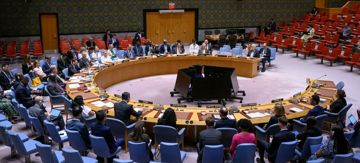 Vue d'ensemble d'une réunion du Conseil de sécurité des Nations Unies dans la salle du ONU , avec les délégués assis autour d'une grande table circulaire.