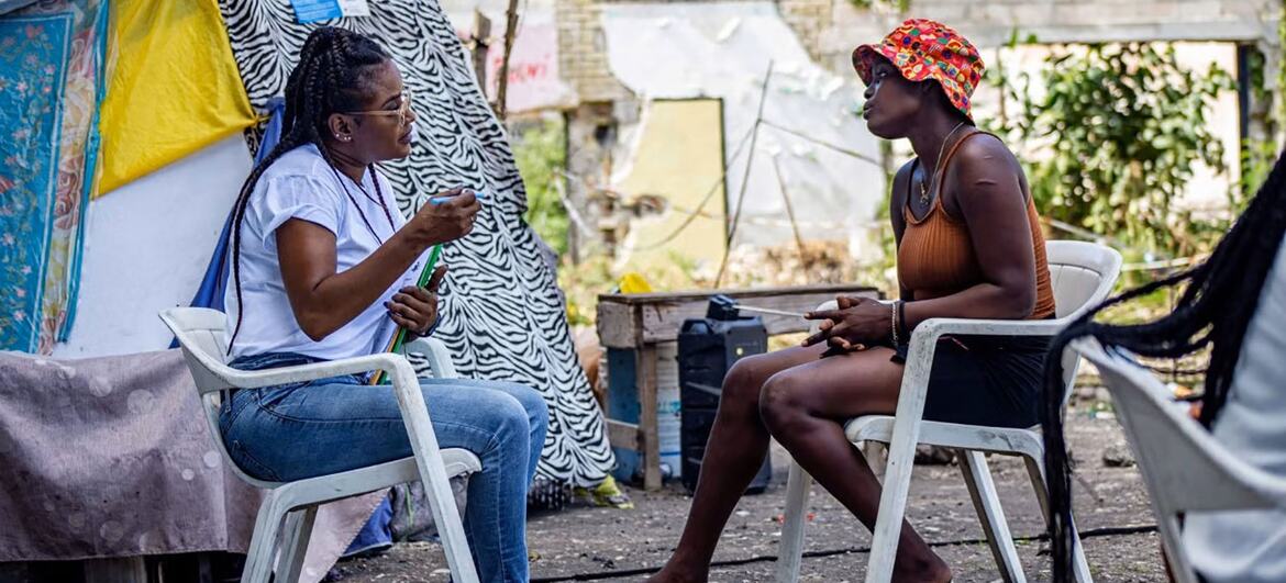 A PAHO/WHO worker provides counseling to a displaced woman in an IDP site in Haiti.