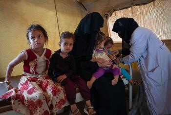 A WFP healthcare worker checks a young child for signs of malnutrition in a tent at a refugee camp in Obock, Djibouti, on May 24, 2023.