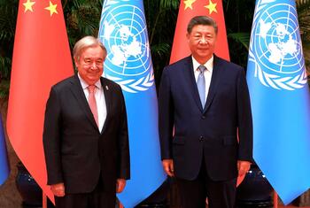 Le secrétaire général de ONU, António Guterres, et le président chinois Xi Jinping posent ensemble pour une réunion, avec les drapeaux de l' ONU et de la Chine en arrière-plan.