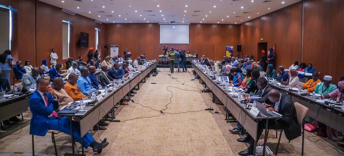 À Dakar, au Sénégal, une grande salle de conférence accueille un atelier régional sur les conventions internationales et leur application par les tribunaux. Des délégués, hommes et femmes, en tenue professionnelle, sont assis à de longues tables. Un écran est visible au fond de la salle.