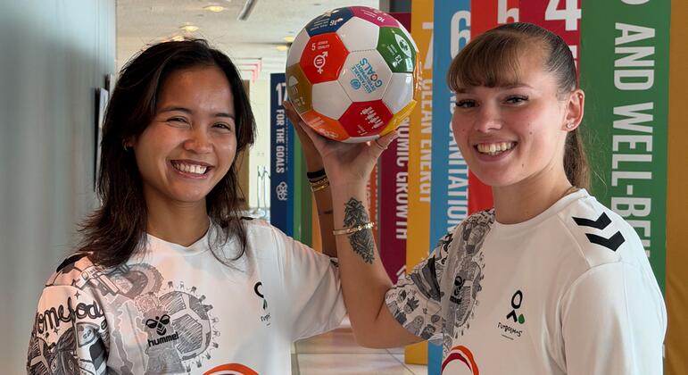 Two female athletes hold a soccer ball during a Street Child United visit to the UN Youth Office for an event on football and mental health.