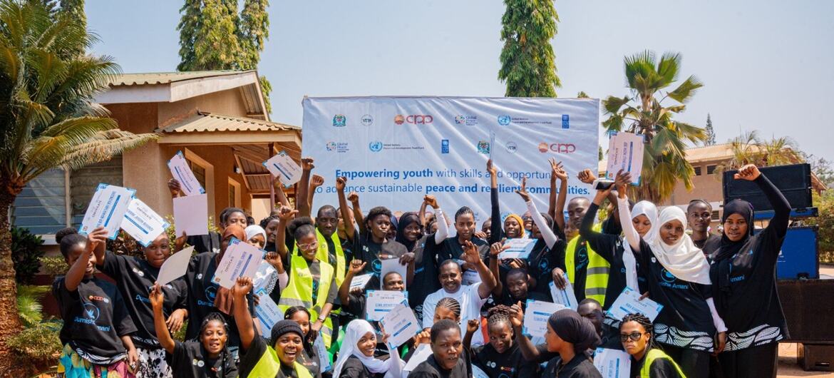 Kundi la vijana wakisherehekea wakiwa na vyeti katika hafla ya uwezeshaji wa UNDP nchini Tanzania.