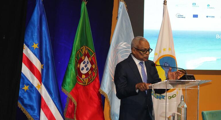 José Maria Neves, Presidente de Cabo Verde, discursa num pódio com as bandeiras de Cabo Verde, Portugal e das Nações Unidas atrás dele.