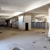 Intérieur d'un bâtiment abandonné et délabré de la prison de Sidnaya, en Syrie, avec de la peinture écaillée et des débris au sol.