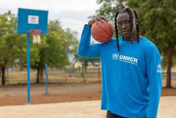 L'ambassadrice de bonne volonté du HCR, Wenyen Gabriel, tient un ballon de basket sur un terrain extérieur dans le comté de Maban, au Soudan du Sud.