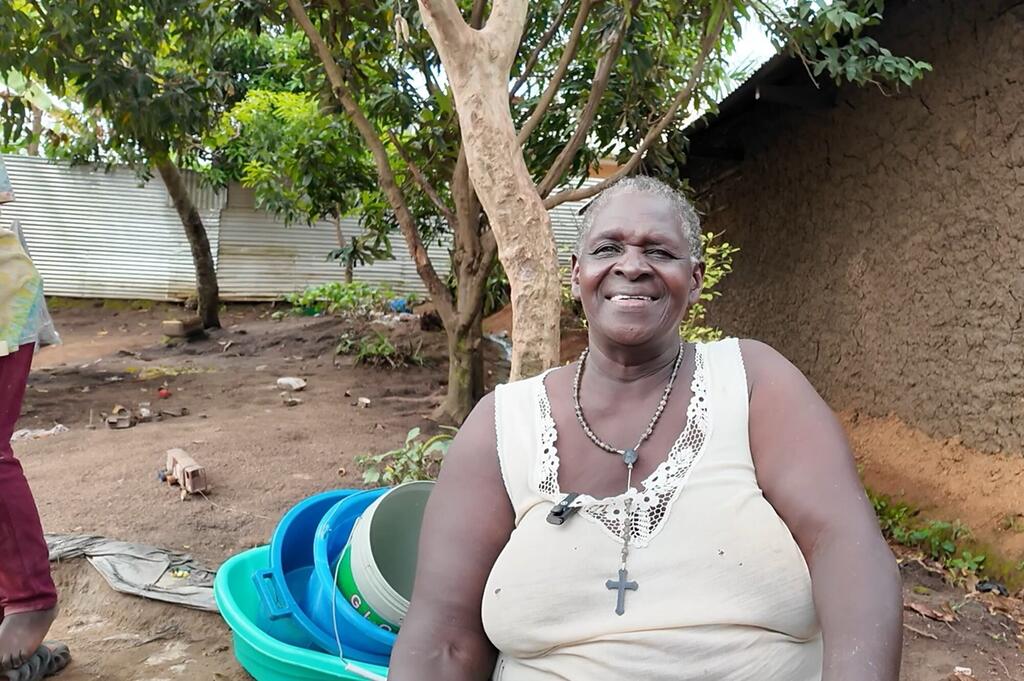 Mwanamke mwenye tabasamu katika mazingira ya vijijini katika Jamhuri ya Kidemokrasia ya Kongo, wakati wa kampeni ya uhamasishaji kuhusu Ebola huko Ituri.