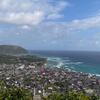 Une ville côtière des médinas des sultanats historiques des Comores, avec une mosquée visible au premier plan et une colline surplombant l'océan Indien.