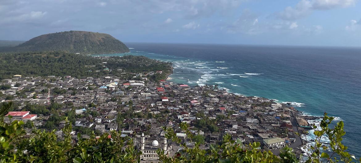 科摩罗历史苏丹国麦地那的一个沿海城镇，前景可见一座清真寺，远处有一座小山俯瞰印度洋。